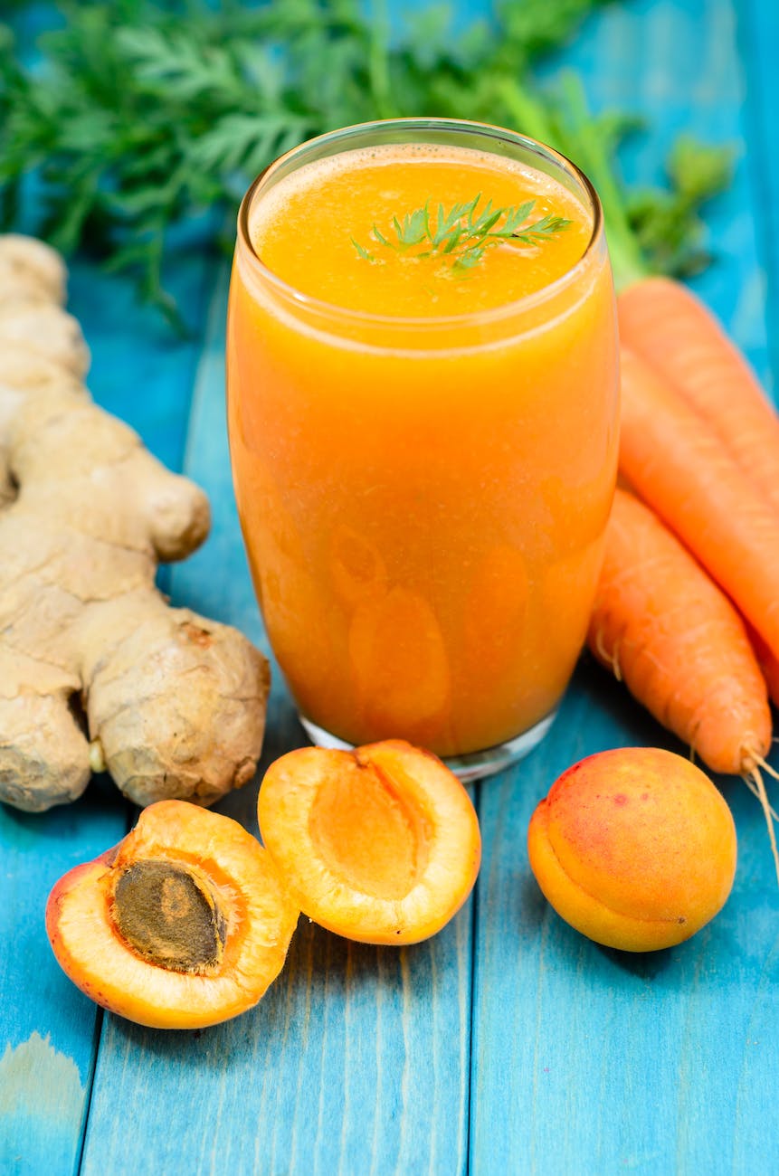 glass of apricot carrot juice on blue wooden table